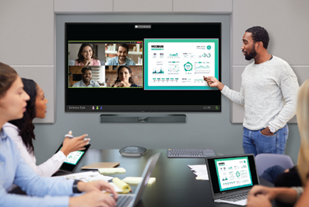 Man presenting using a Pro AV display in a conference room with others sitting at the table