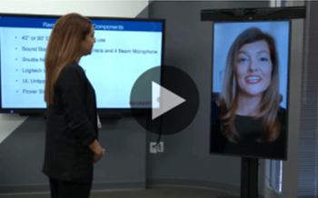 Image of a woman standing in front of a Sharp display showing person demonstrating the remote concierge